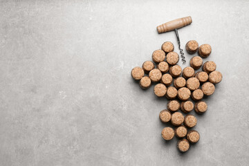 Sticker - Grape made of wine bottle corks and corkscrew on light grey table, top view. Space for text