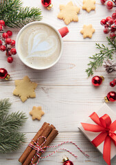 Wall Mural - Cup of latte coffee and Christmas decoration on a white wooden background