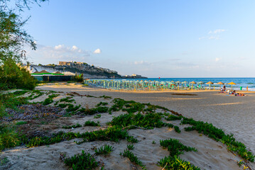 Wall Mural - Vieste, Italy. View of Pizzomunno beach with the town of Vieste far in the background, at late afternoon. September 9, 2022.