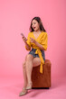 Beautiful Asian woman in summer holding smartphone and credit card online shopping on pink background.