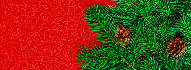 Wall Mural - christmas fit tree on a red shiny background top view, copyspace. xmas, nature new year concept..