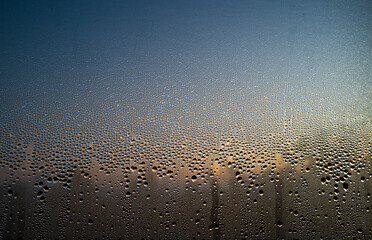 Canvas Print - condensation from a drop of water on a window pane during an autumn dawn