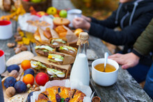Picnic In The Autumn Season, Food On A Wooden Table, Hot Tea, Pastries And Sandwiches