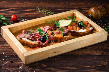 Canvas Print - Assorted bruschetta with salmon, beef cut, sun-dried tomatoes, onion, mushrooms, cream cheese and baguette.