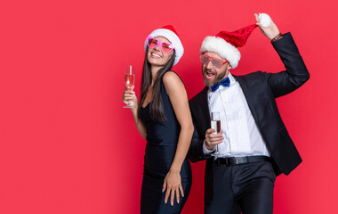 Wall Mural - lets celebrate holiday. christmas glad couple celebrate with champagne isolated on red.