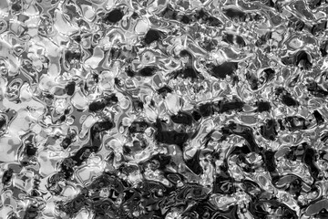 Background of molten metal, liquid steel close-up. Liquid metal texture, shiny reflective surface, copy space