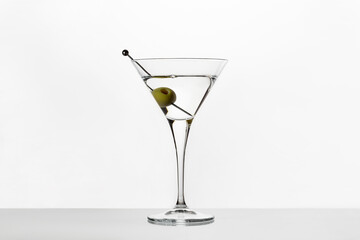 Martini glass with olives on white background