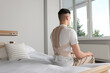 © New Africa - Man with orthopedic corset sitting in bedroom