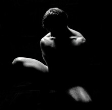 Artistic Male Model Silhouette Posing Nude Accenting Muscular Definition With Black Background