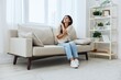© SHOTPRIME STUDIO - Woman sitting on sofa at home arm and shoulder pain, muscle sprain and joint pain, calcium problems in bones