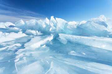 winter natural background with fragments of blue ice and heaps of pieces of ice floes on lake baikal