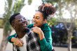 © Daniel - Happy black man carrying girlfriend on back. Playful young couple. Boyfriend and girlfriend looking at each other eyes.