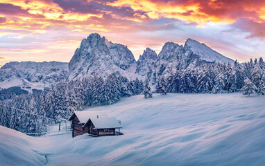 fantastic cloudscape in italian ski resort. frosty sunnrise in alpe di siusi village with plattkofel