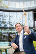 © Westend61 - Mature businessman holding wind turbine outside office building
