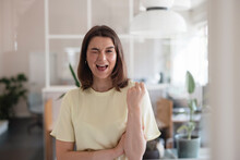 Happy Businesswoman Winking And Gesturing Fist In Office