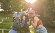 Happy Young Women Wearing Animal Mask Having Fun In Park