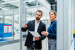 © Westend61 - Businessman holding document pointing by colleague at factory