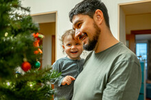 Smiling Father With Son Looking At Christmas Tree