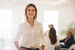 © Jacob Lund - Cheerful young businesswoman standing in a meeting room