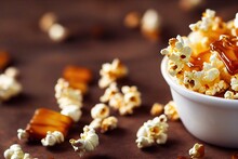 White Bowl With Caramel Popcorn And Scattered Around Grain On Brown Background