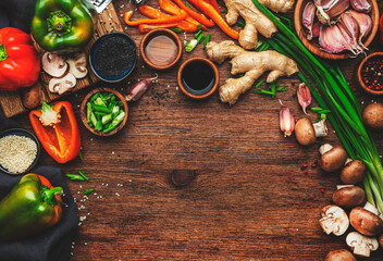 Food background. Asian cuisine cooking ingredients. Paprika, mushrooms, ginger, lime, garlic, soy sauce and rice vinegar on wooden kitchen table. Healthy eating concept. Top view