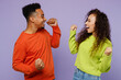 © ViDi Studio - Side view young couple two friend family man woman of African American ethnicity wear casual clothes together do winner gesture celebrate clench fists isolated on pastel plain light purple background