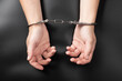 female hands in handcuffs on a dark background, detention arrest..