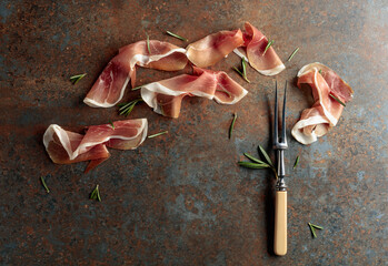 Wall Mural - Prosciutto with rosemary on vintage background.