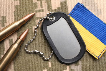 military id tag, bullets and patch on pixel ukrainian camouflage, flat lay
