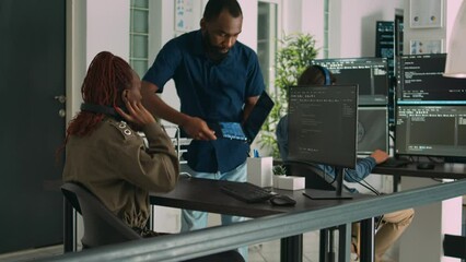 Team of programmers analyzing coding algorithms on laptop and computer in digital agency office. System developers discussing database script and firewall server, big data interface.