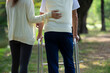 offspring or caregiver, hand support back of a disability senior man not to fall while practice walking with walker in the garden, concept older adult lifestyle, elderly society, senior rehabilitation