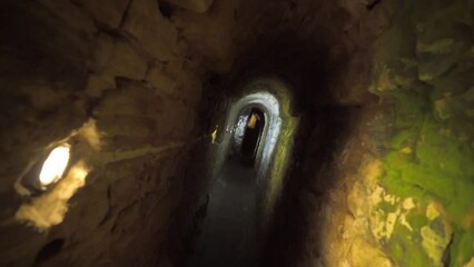 Wall Mural - slow motion rotating dolly shot of a tunnel of catacombs lit with in medina sidonia in cadiz spain with ancient walls in a castle