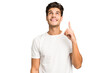 © Asier - Young caucasian handsome man isolated indicates with both fore fingers up showing a blank space.