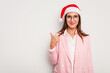 © Asier - Business caucasian woman wearing a christmas hat isolated on white background smiling and raising thumb up