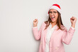 © Asier - Business caucasian woman wearing a christmas hat isolated on white background raising fist after a victory, winner concept.