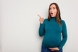 © Asier - Pregnant caucasian woman isolated on white background pointing to the side