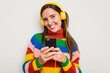 © Asier - Young caucasian woman listening to music with headphones touching her mobile phone