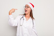 © Asier - Young caucasian doctor woman wearing a santa hat isolated on white background
