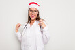 © Asier - Young caucasian doctor woman wearing a santa hat isolated on white background