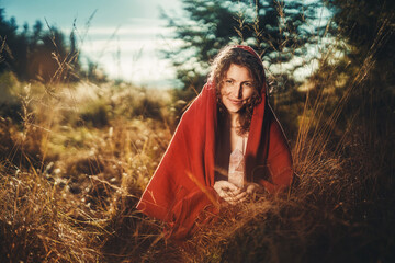 Beautiful shaman woman in nature and ceremony of the earth. Woman holding a large crystal of rosary in her hands.