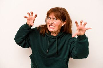 Middle age caucasian woman isolated on white background upset screaming with tense hands.