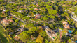 Aerial view of a prestigious residential area at sunset. Almost all the houses are villas with a pool and garden.