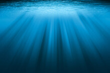 Underwater Background With Copy Space. Blue Water With Sunbeams.