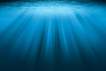 underwater background with copy space. blue water with sunbeams.