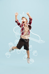 Creative design with drawn elements. Portrait of cheerful little boy, child having fun with music. Future guitar player and singer