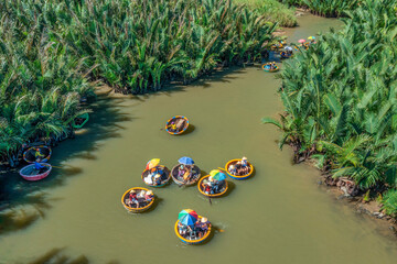 AERIAL VIEW, TOURISTS FROM THAILAND, KOREA, AMERICA AND JAPAN ARE RELAX AND EXPERIENCING A BASKET BOAT TOUR AT THE COCONUT WATER ( MANGROVE PALM ) FOREST IN CAM THANH VILLAGE, HOI AN,QUANG NAM,VIETNAM