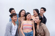 © Mdv Edwards - A group of seven happy and close friends in their late teens to early 20s smiling while looking at each other. Modern Gen Z team. Isolated on a white background.