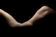 artistic nudity attractive male model posing on side accenting body curvature with black background,
