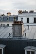 Zinc rooftops with TV antennas and a group of chimneys under cloudy sky in Montmartre, Paris, France
