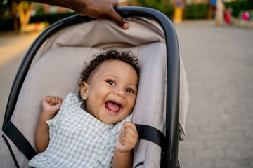 caring parent rocking his smiling baby in a stroller